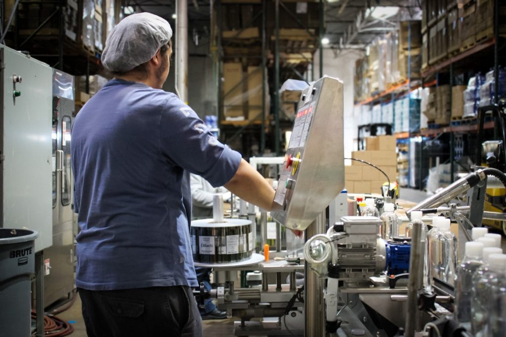 Texas Water House team member operating the bottle labeling line